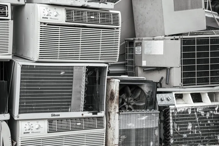 Old white goods stacked for recycling at a transfer station