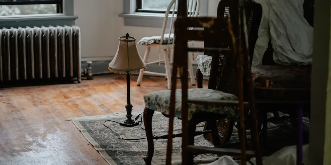 A front room stacked with furniture and boxes before a clearance starts
