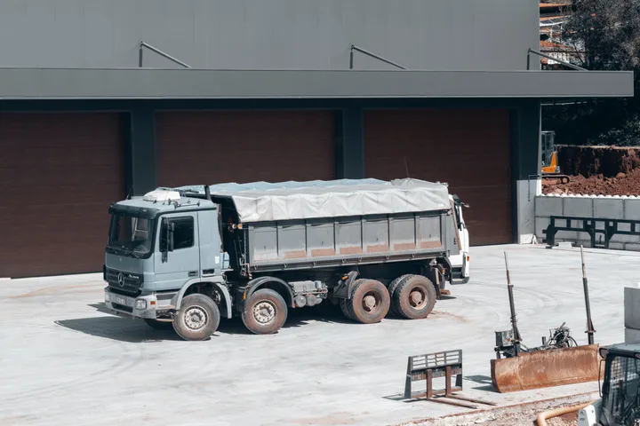 A tipper truck standing in a yard at the end of the round, its body still loaded